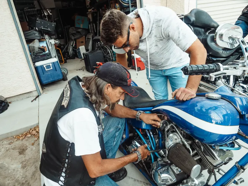 Manos de una persona trabajando en el mantenimiento de una moto